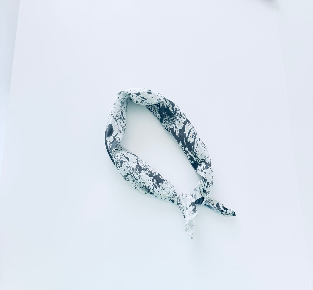 Black and white bandana with distressed streetwear look laying on white table